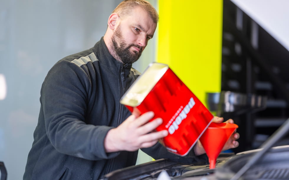 Kfz Mechaniker Gießt Frisches Motoröl In Den Motor